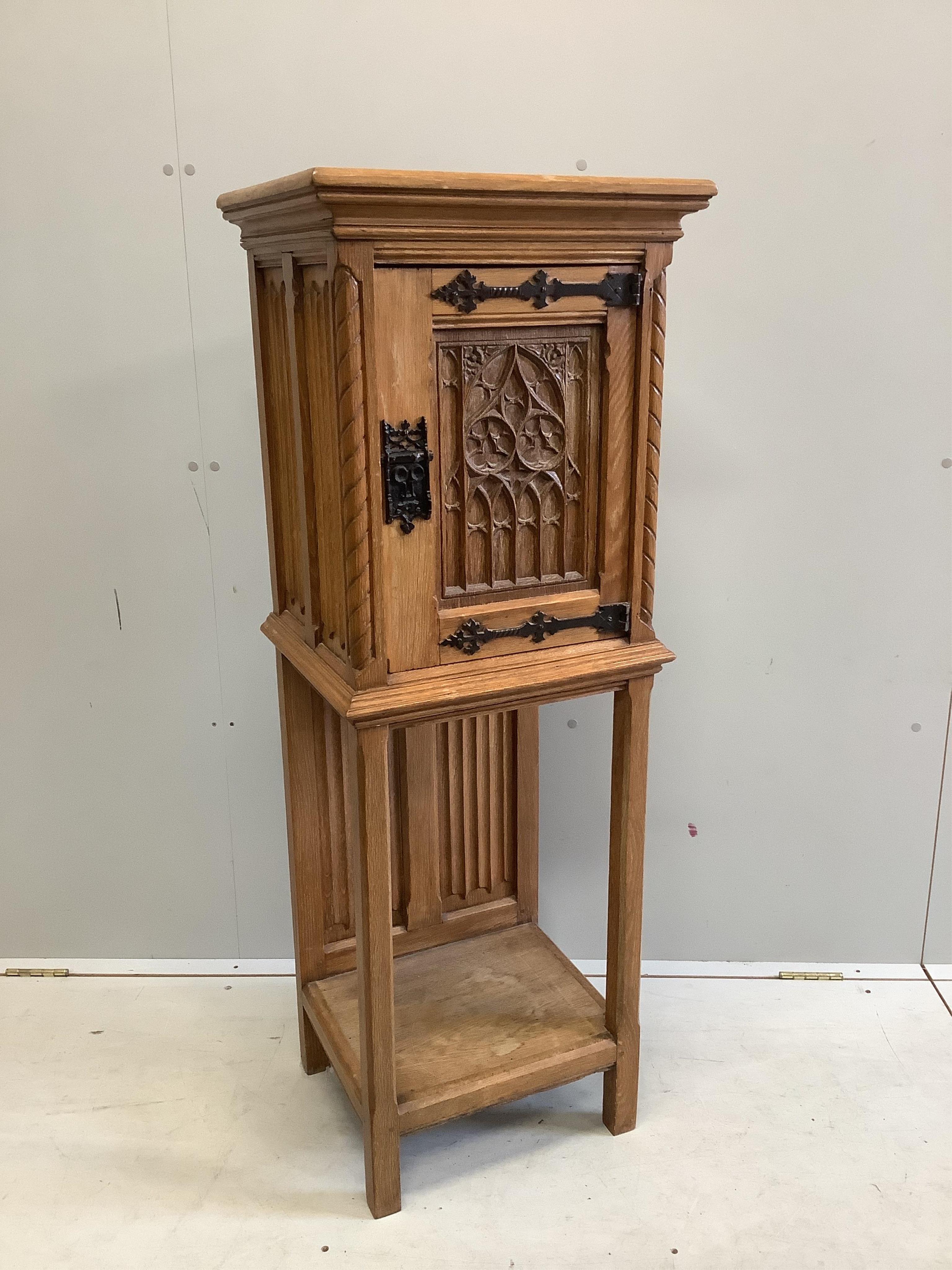 A Gothic Revival oak cabinet on stand, width 46cm, depth 38cm, height 127cm. Condition - fair